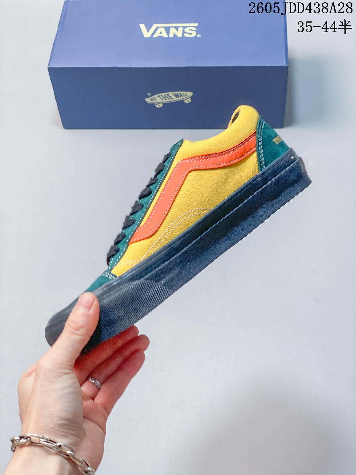 Side profile of the color-blocked yellow, teal, and orange low-top sneaker