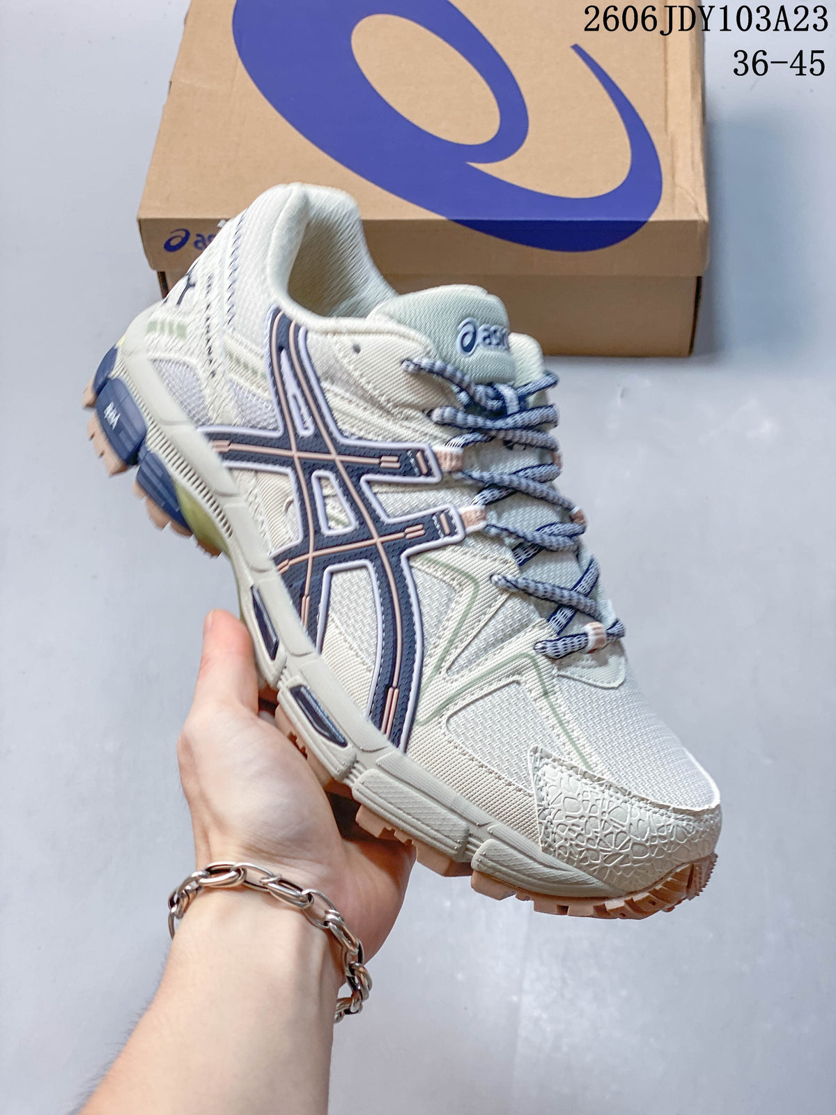 Angled view highlighting the cream upper, navy side detailing, and treaded sole