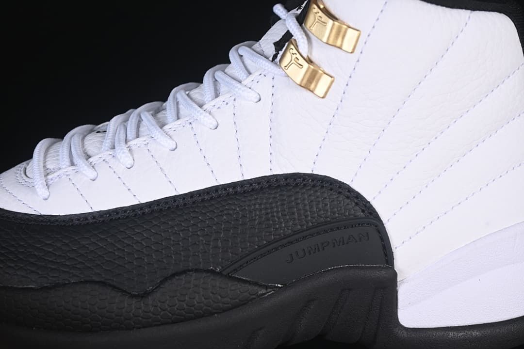 Close-up of the white upper, black overlay and gold-tone lace hardware.