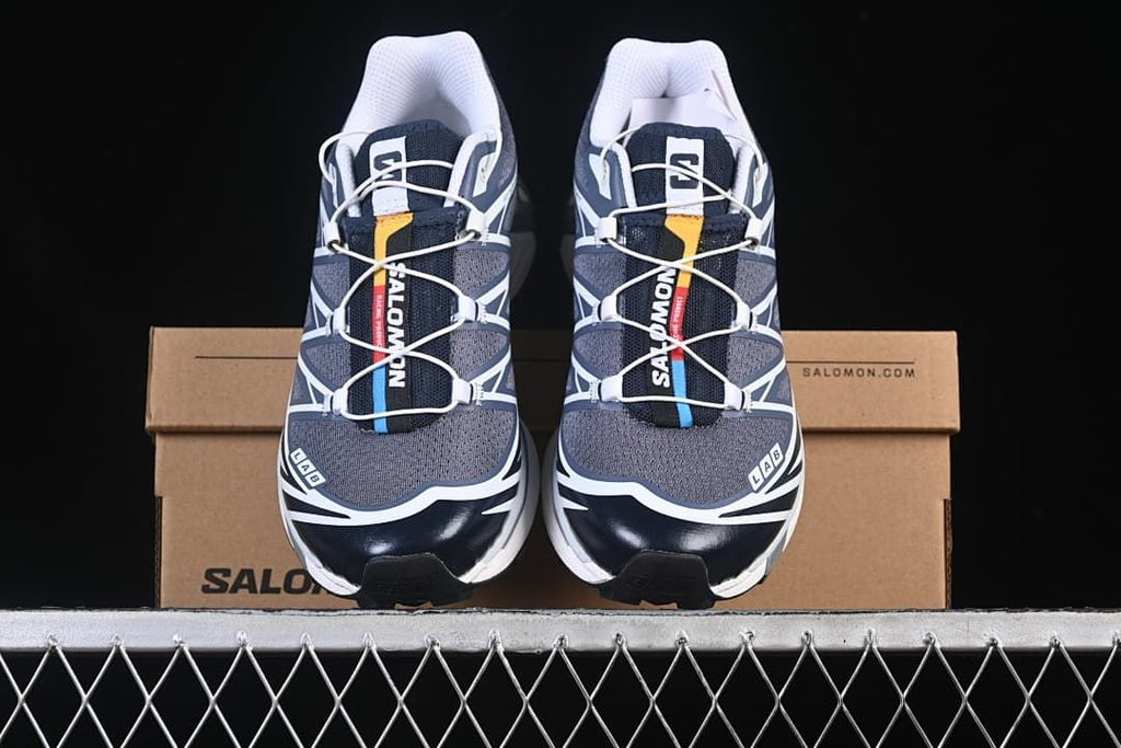 Pair of navy, gray, and white shoes displayed on a box