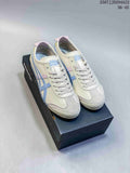 Pair of cream Onitsuka Tiger Mexico 66 Deluxe sneakers with blue stripes and pastel accents on a shoebox