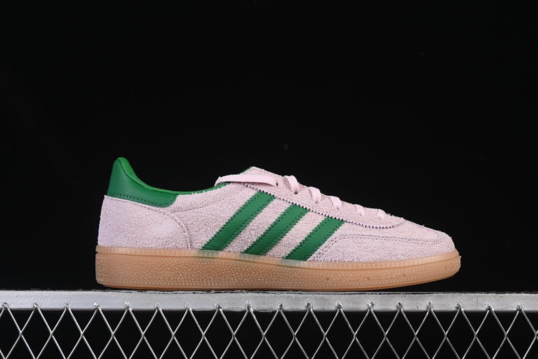 Side profile of the pale pink sneaker with green stripes and gum sole