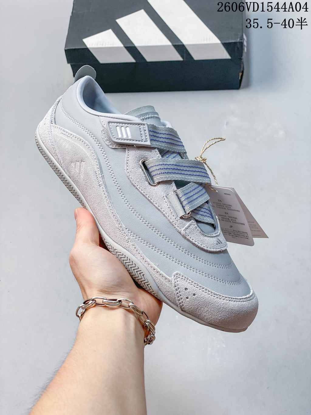 Angled side view of the light gray Adidas Urban Reverie sneaker and strap details
