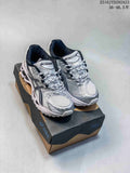 Pair of silver and white ASICS GEL-Nimbus sneakers displayed on a shoebox