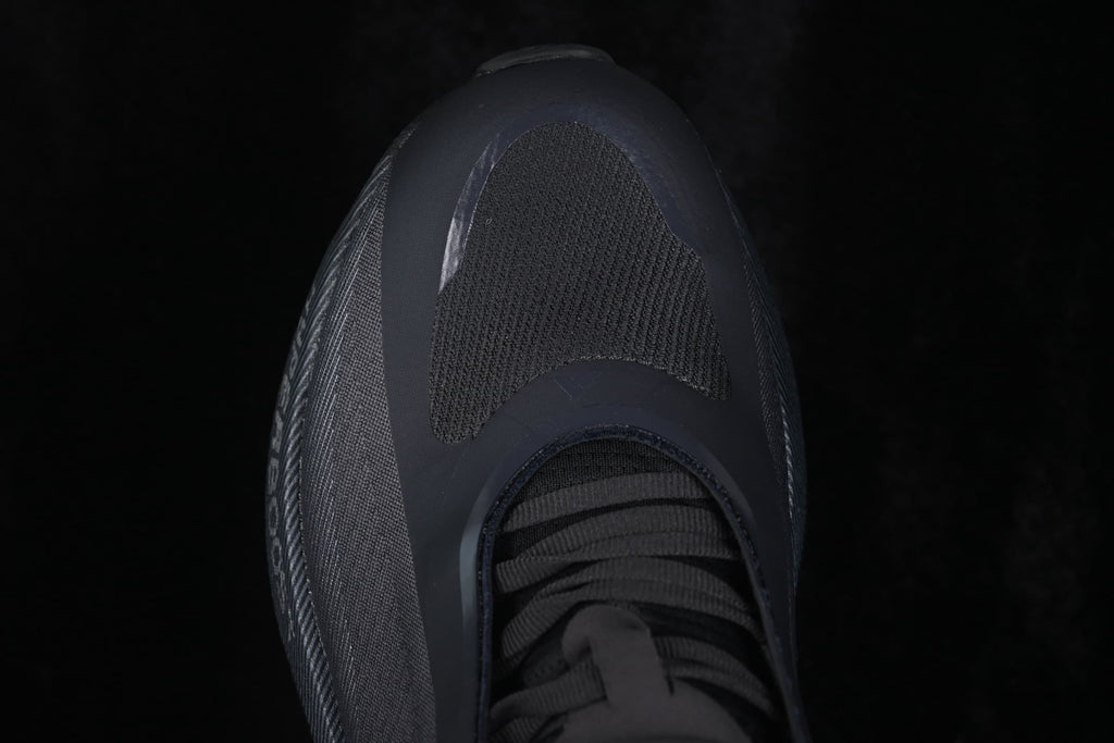 Top-down close-up of the toe box, textured forefoot panel, and black laces.