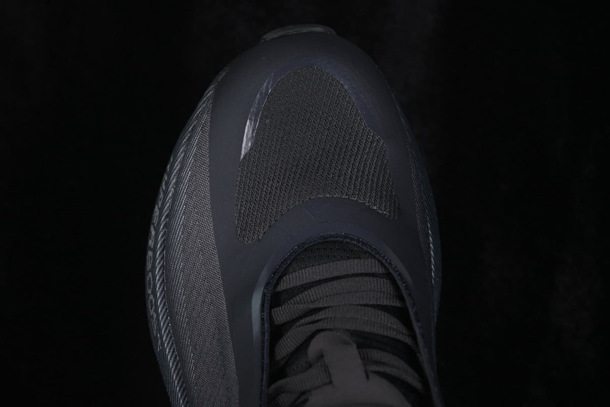 Top-down close-up of the toe box, textured forefoot panel, and black laces.