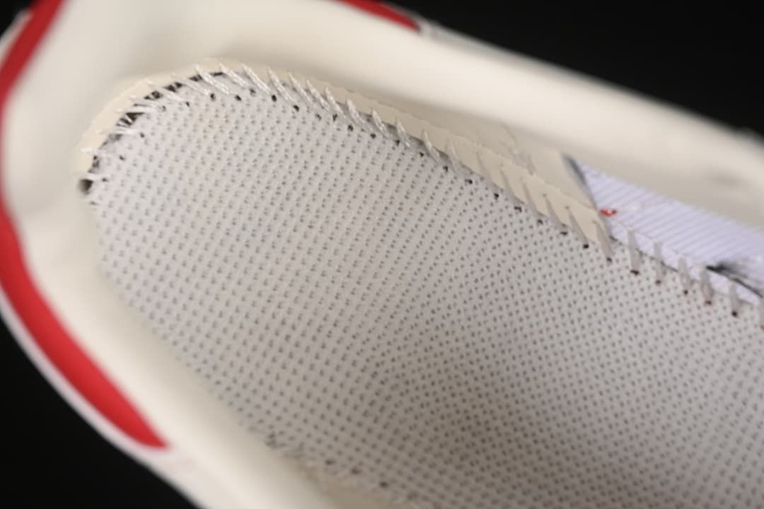Close-up of the sneaker’s perforated inner lining and red heel accent.