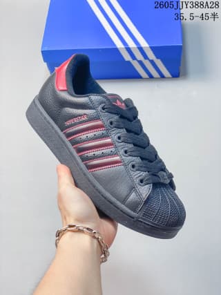 Angled side view of the dark sneaker with red-striped side panels