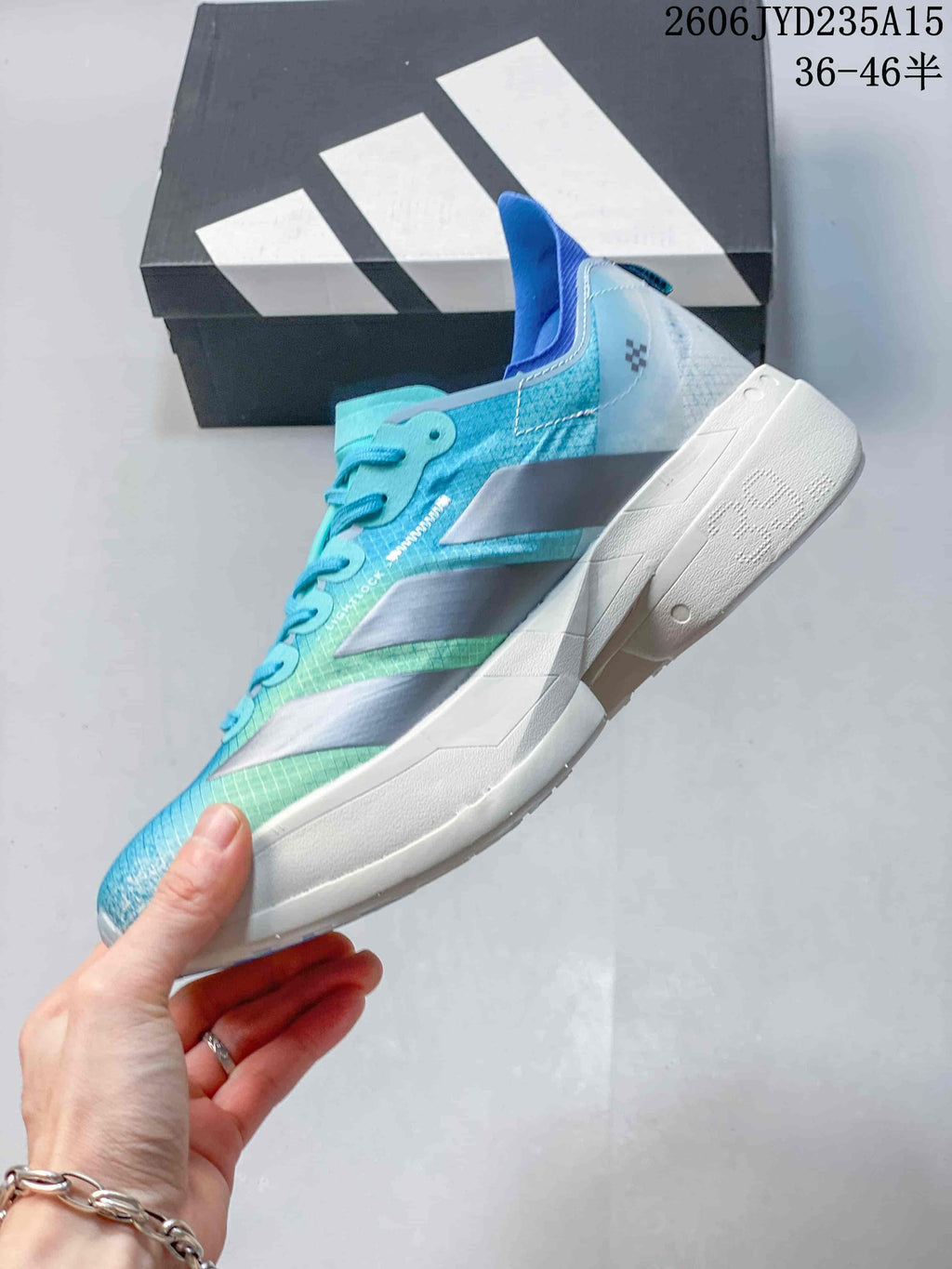 Side profile of a blue and turquoise running shoe with silver stripes