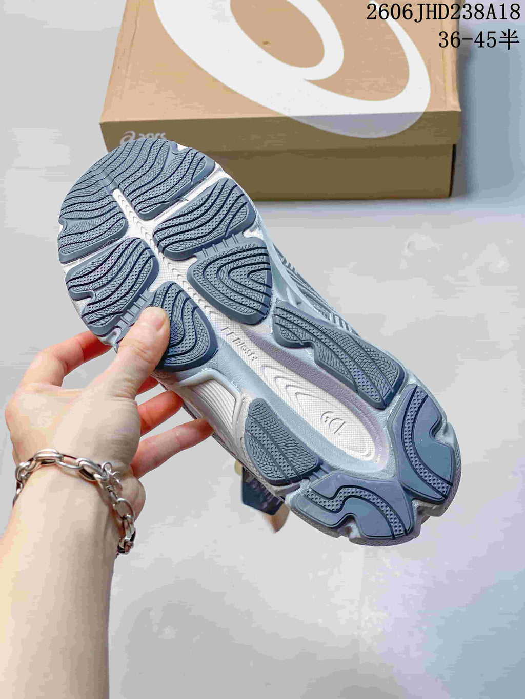 Close-up of the patterned outsole on a grey and blue sneaker