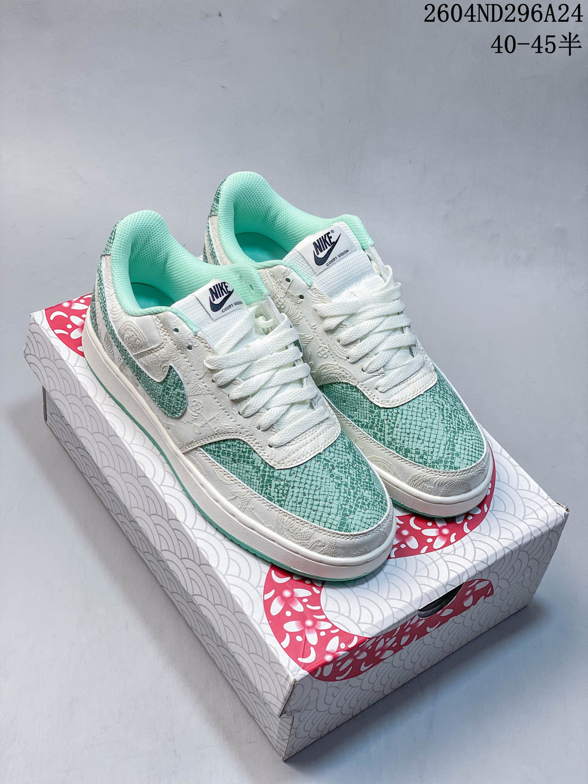 Pair of white and mint-green Nike Court Vision Low sneakers with snake-scale patterned panels on a Year of the Snake 2025 box