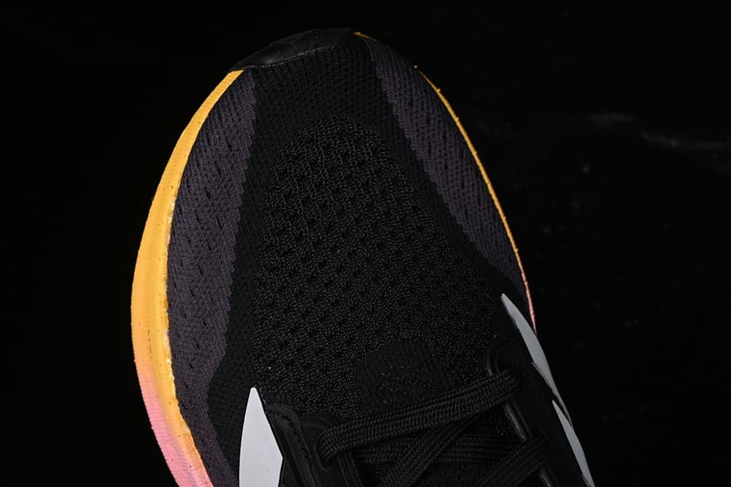 Top view of the black knit-style toe and yellow-pink midsole edge.