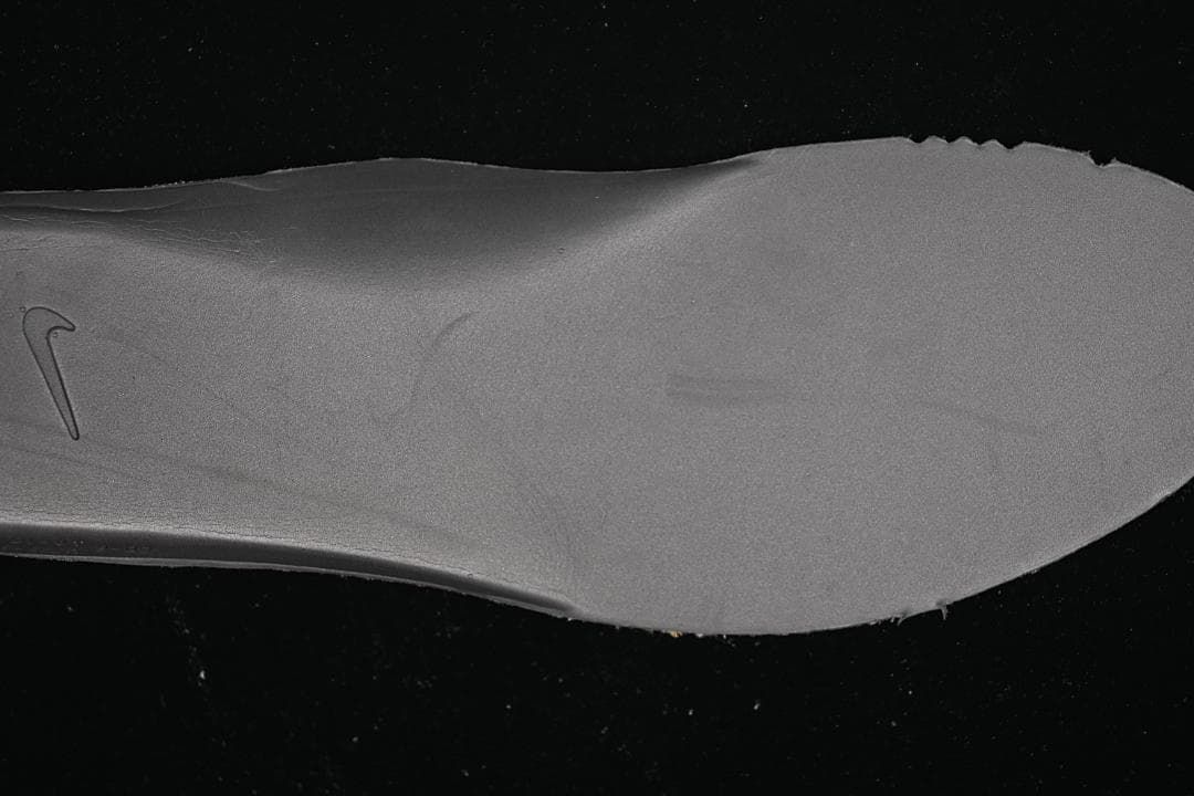 Gray shoe insole with a small Nike Swoosh mark.