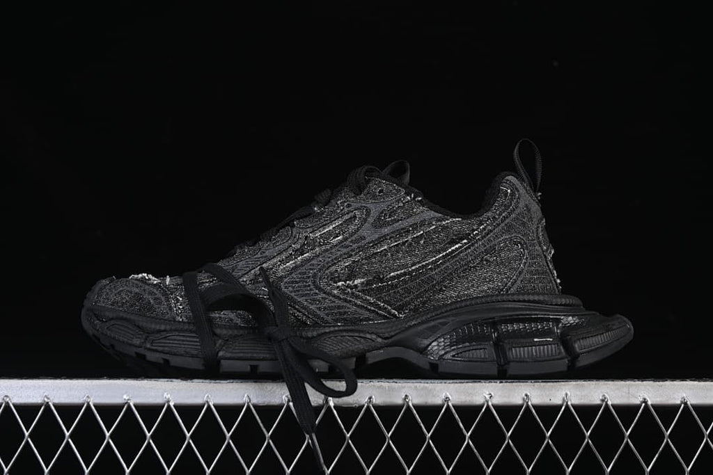 Black Balenciaga 10XL sneaker shown in profile on a display stand.