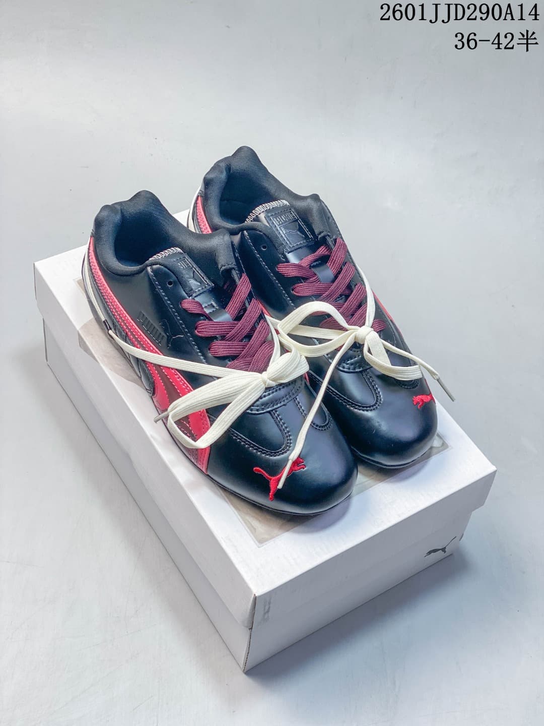 Pair of navy PUMA Speedcat TTF sneakers with pink accents and cream crossover laces.