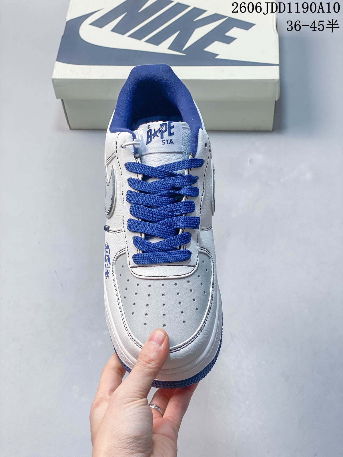Front view of a white sneaker with blue laces and a perforated toe