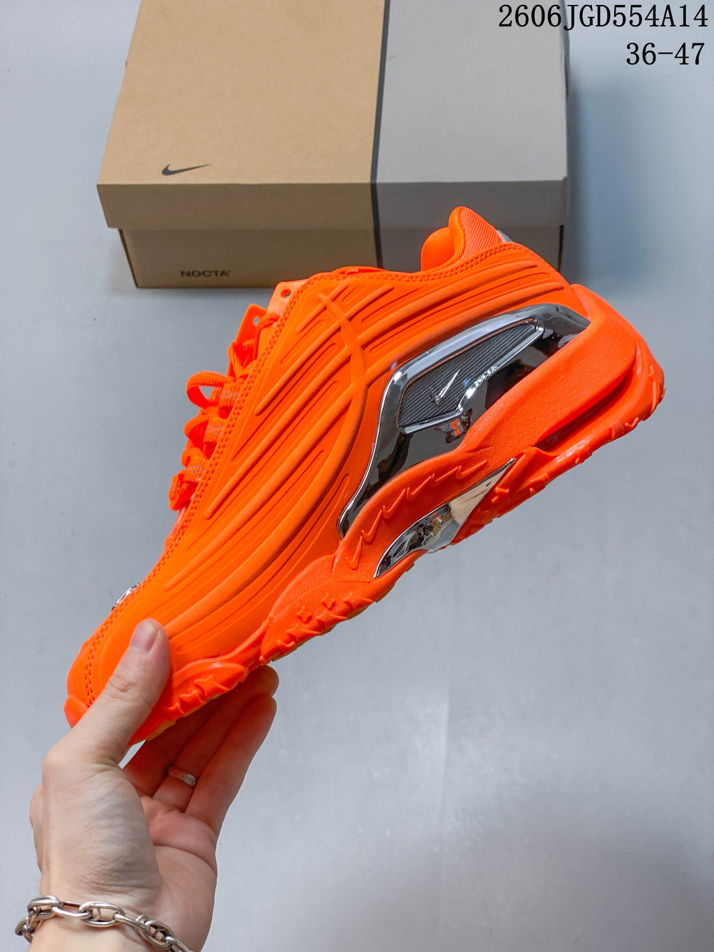 Side profile showing sculpted orange panels and reflective silver accents