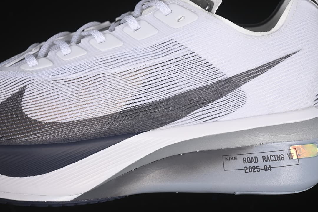 Side close-up of the dark Swoosh, textured upper, and road racing graphic.