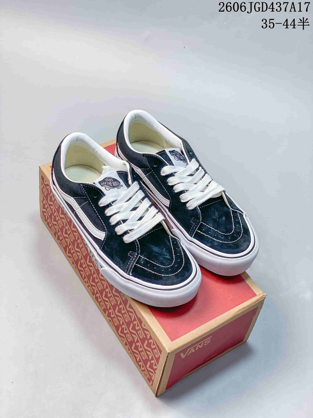 Pair of navy and white Vans low-top sneakers displayed on a shoe box