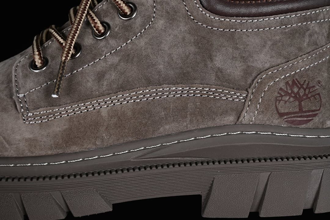 Close-up of side logo, stitched panels, and lugged outsole