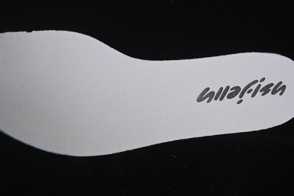 Close-up of a light-colored insole with printed branding