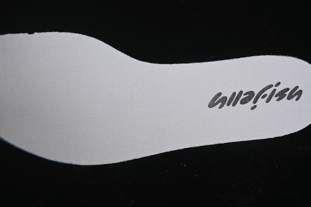 Close-up of a light-colored insole with printed branding