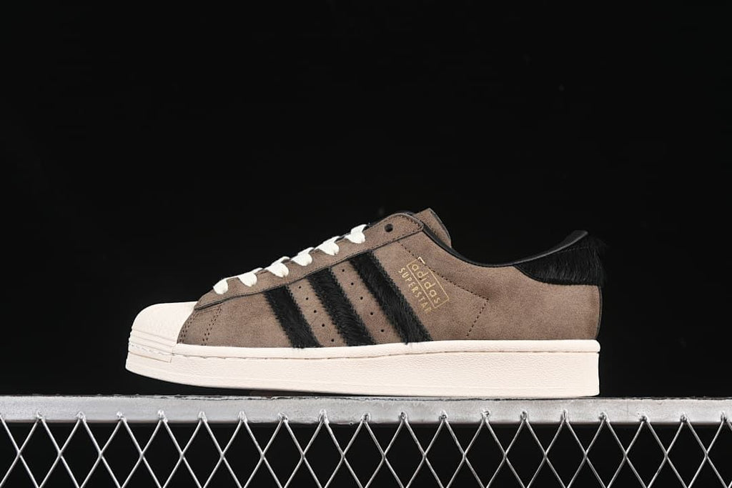Side profile of one brown and black Superstar sneaker