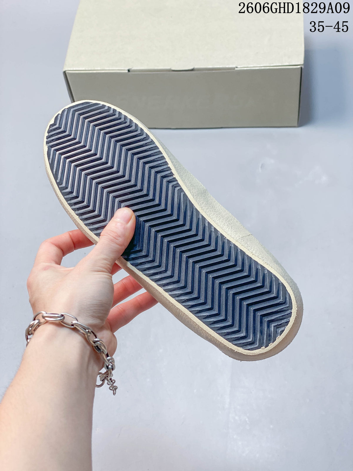 Underside of sneaker showing a dark blue chevron-patterned outsole