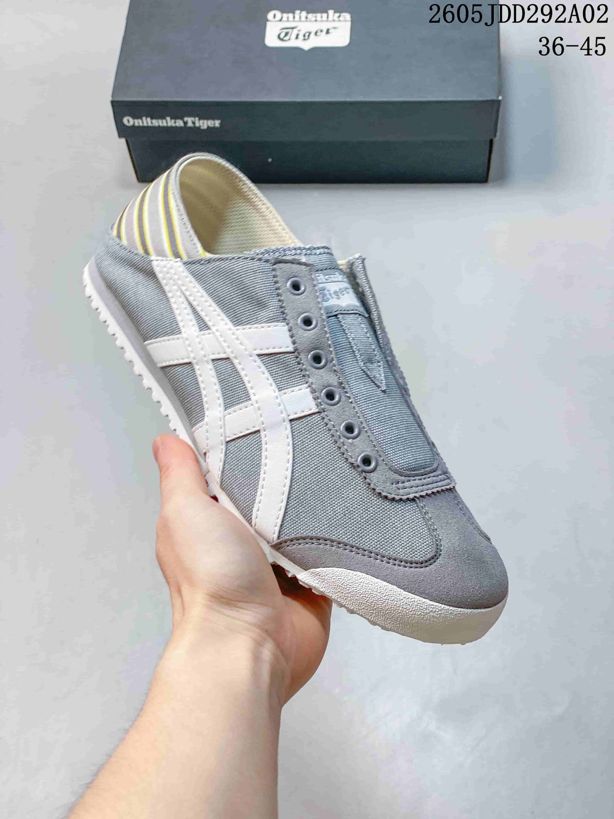 Angled view of the gray slip-on sneaker with white side stripes