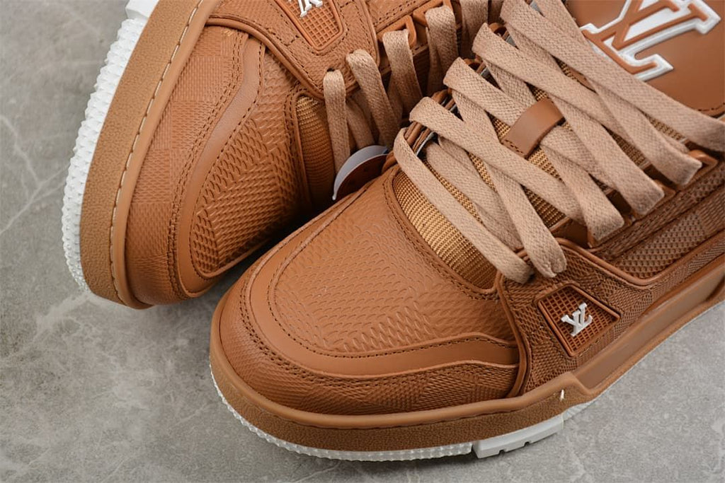 Close-up of textured brown panels and stitching on the sneaker upper.
