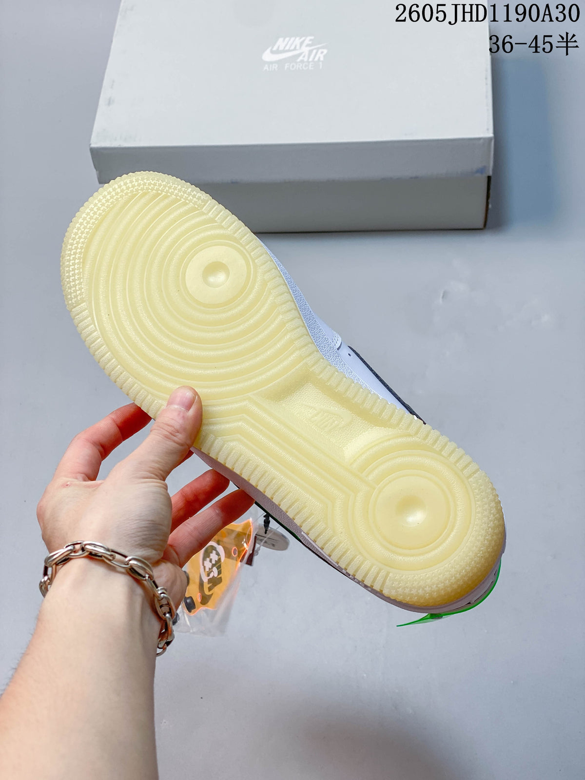 Close-up of the sneaker’s translucent pale-yellow outsole and Nike Air Force 1 box