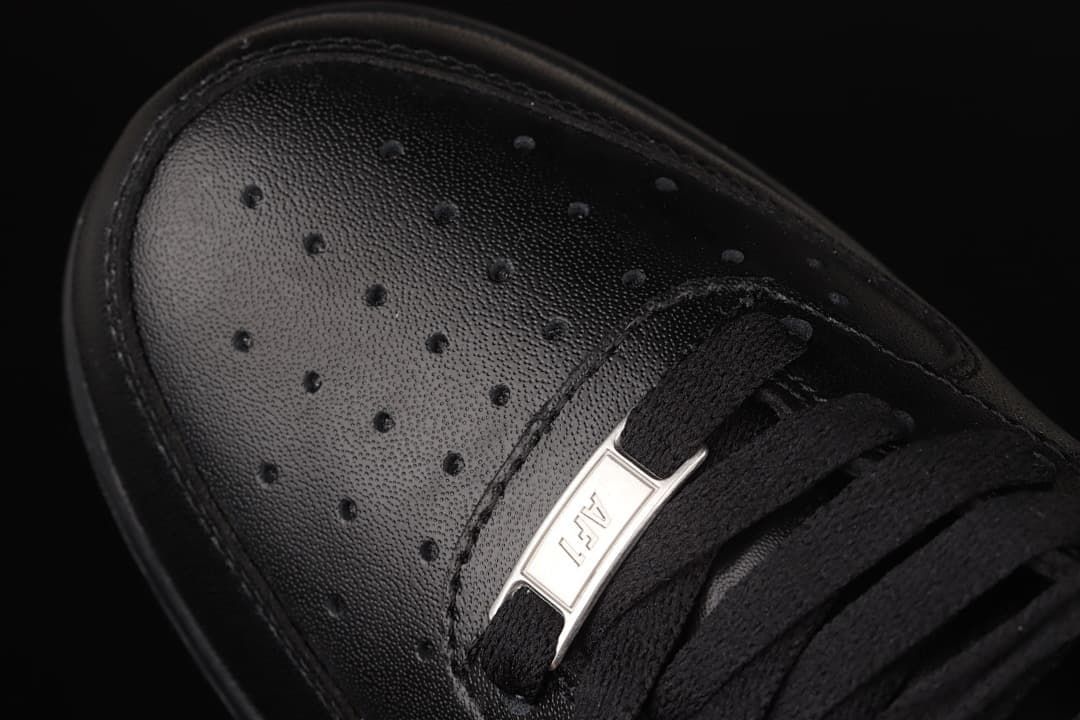 Close-up of perforated toe, black laces, and metallic lace tag.