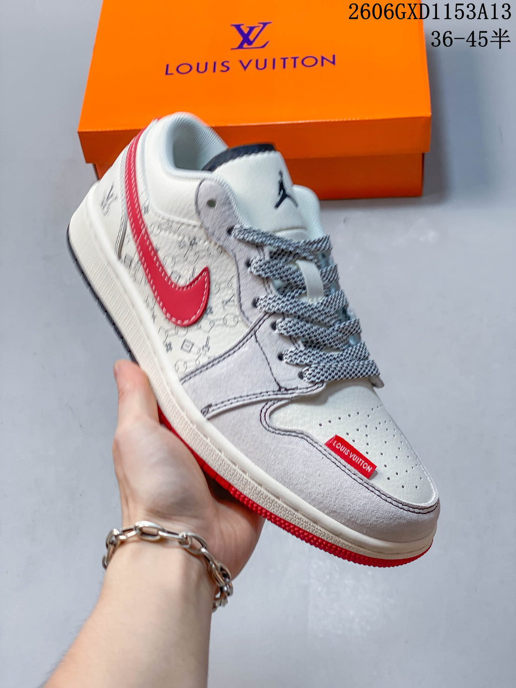 Angled side view of the light-colored sneaker with red accents and patterned detailing