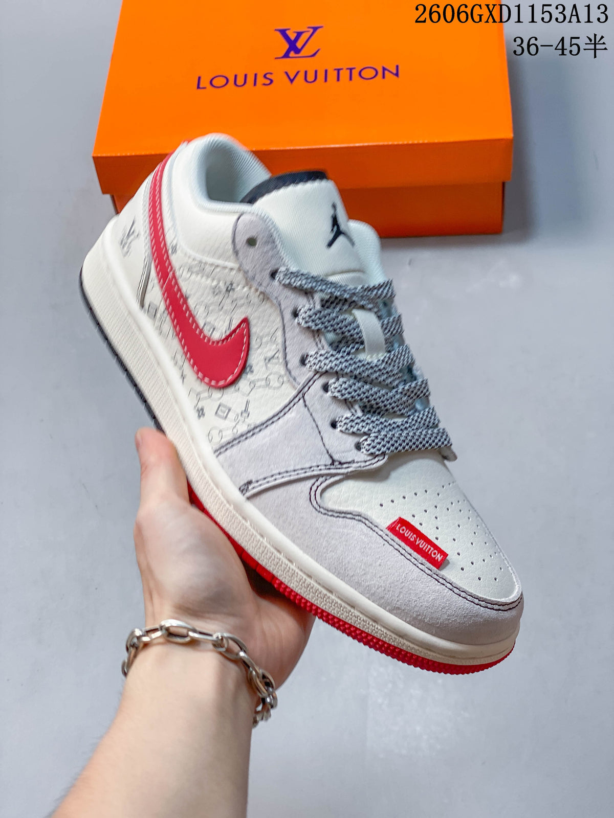 Angled side view of the light-colored sneaker with red accents and patterned detailing