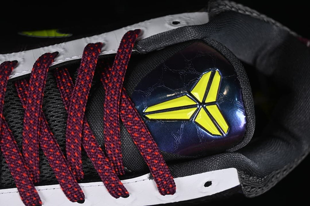 Close-up of the shoe tongue emblem and burgundy laces.