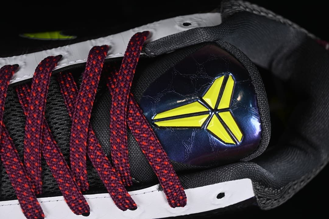Close-up of the shoe tongue emblem and burgundy laces.