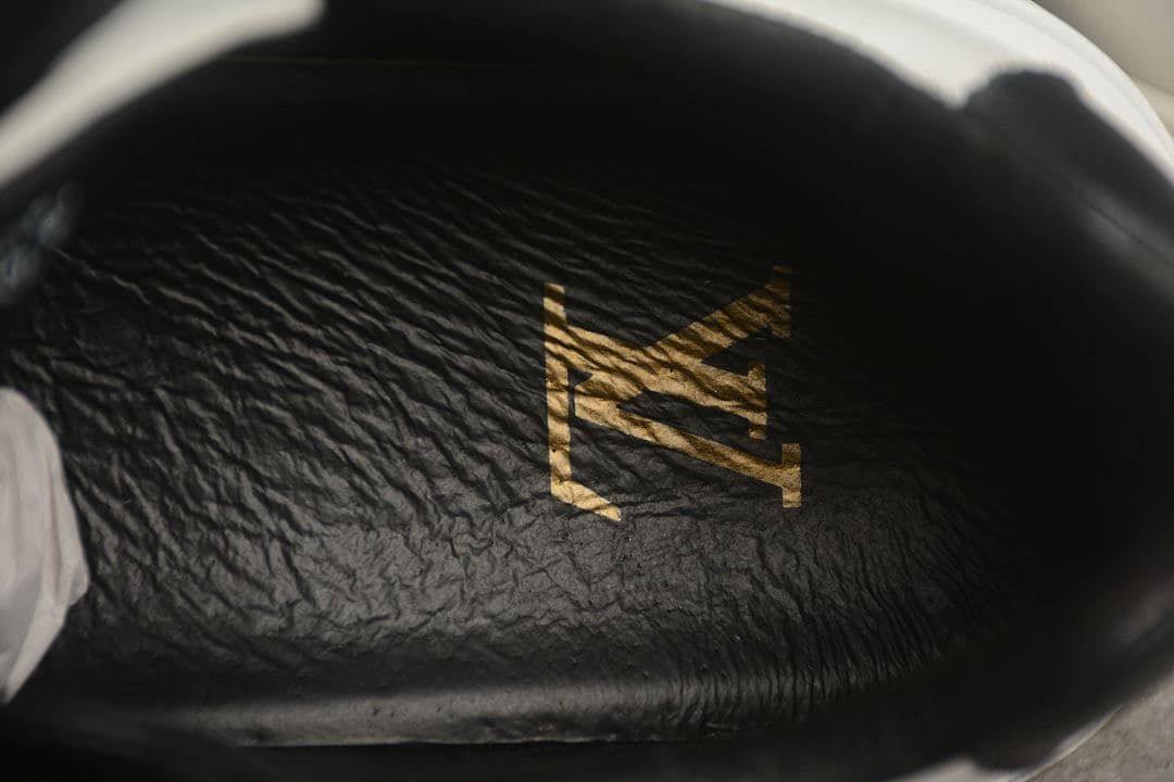Close-up of the sneaker’s dark insole with a gold-toned logo