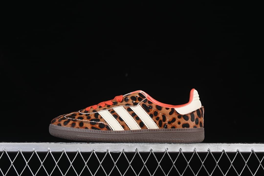 Side view of leopard-print Adidas Samba OG W sneakers with cream stripes, orange-red accents, and a dark brown outsole