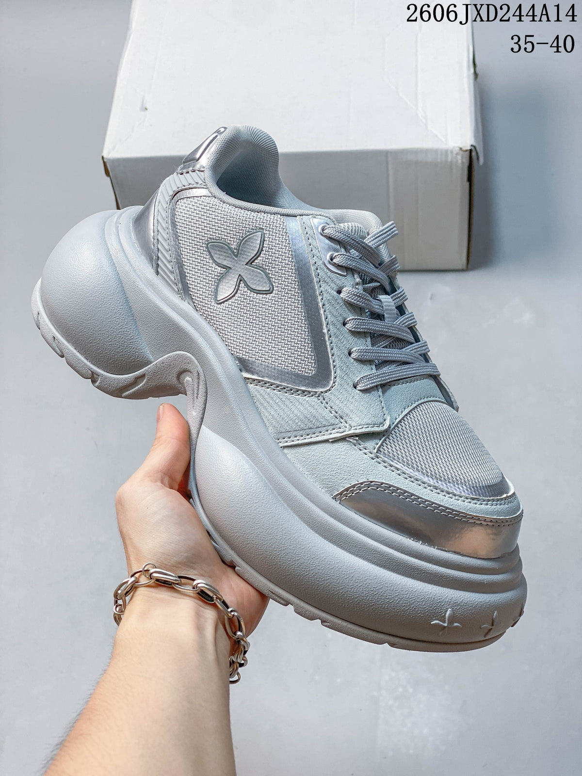 Side view of a pale gray SMFK sneaker