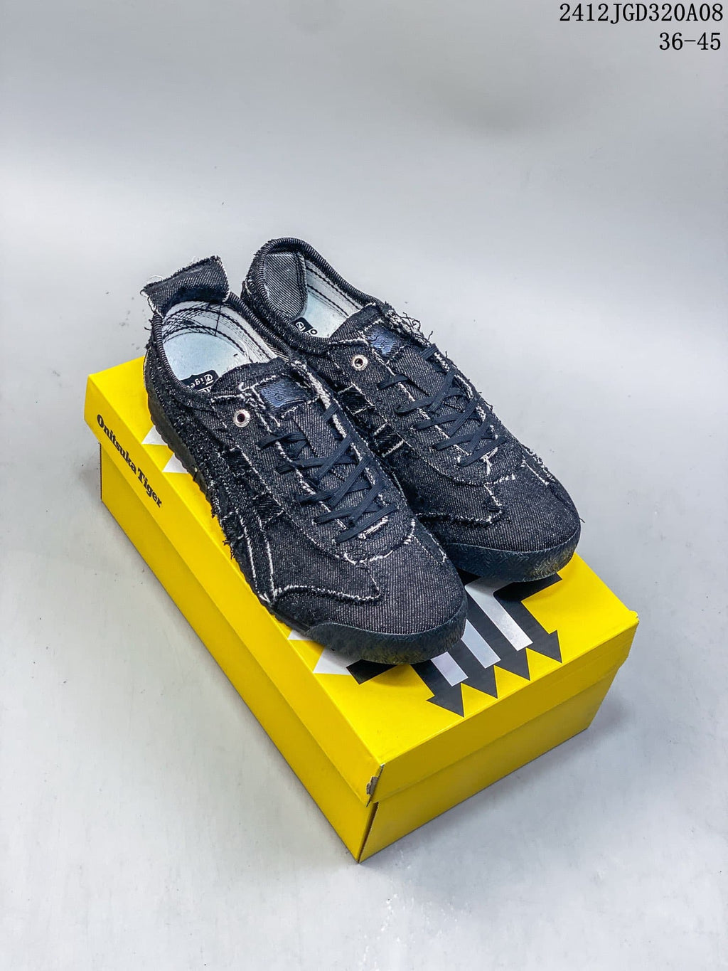 Pair of dark denim-style Onitsuka Tiger Mexico 66 SD low-top sneakers on a yellow shoe box