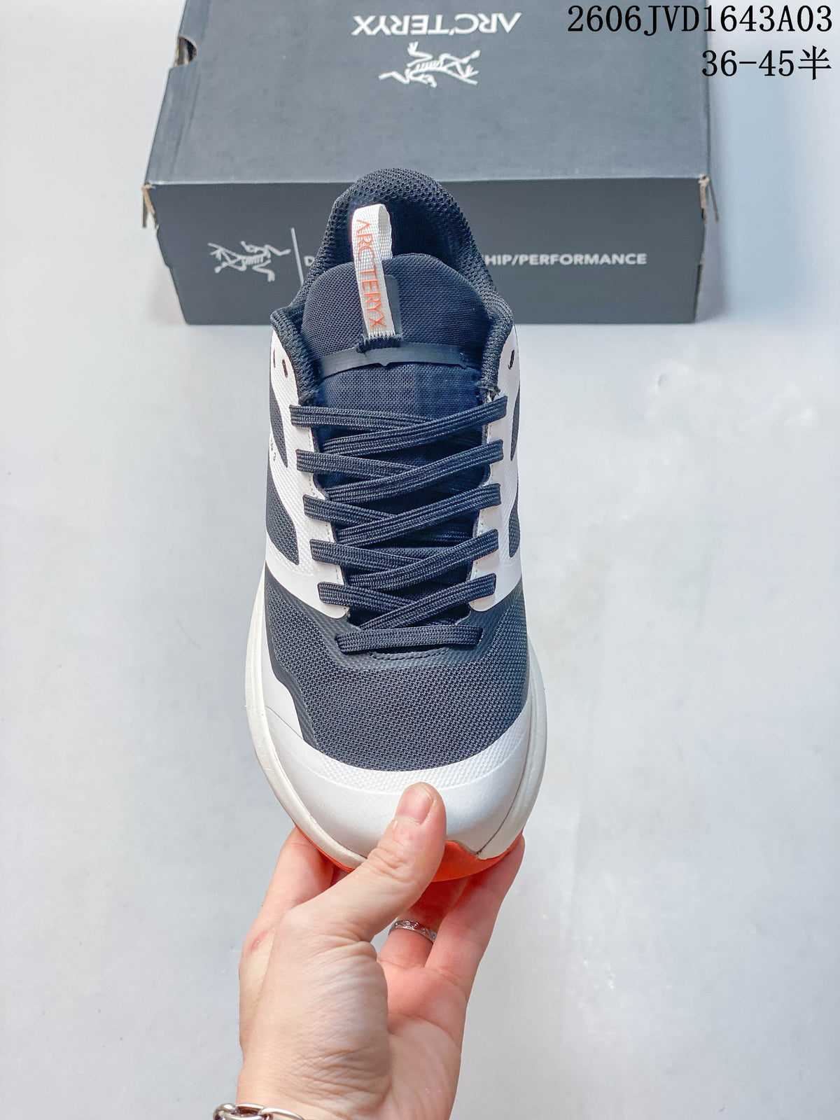 Front view showing the navy mesh-like upper, white overlays, and lace-up closure.