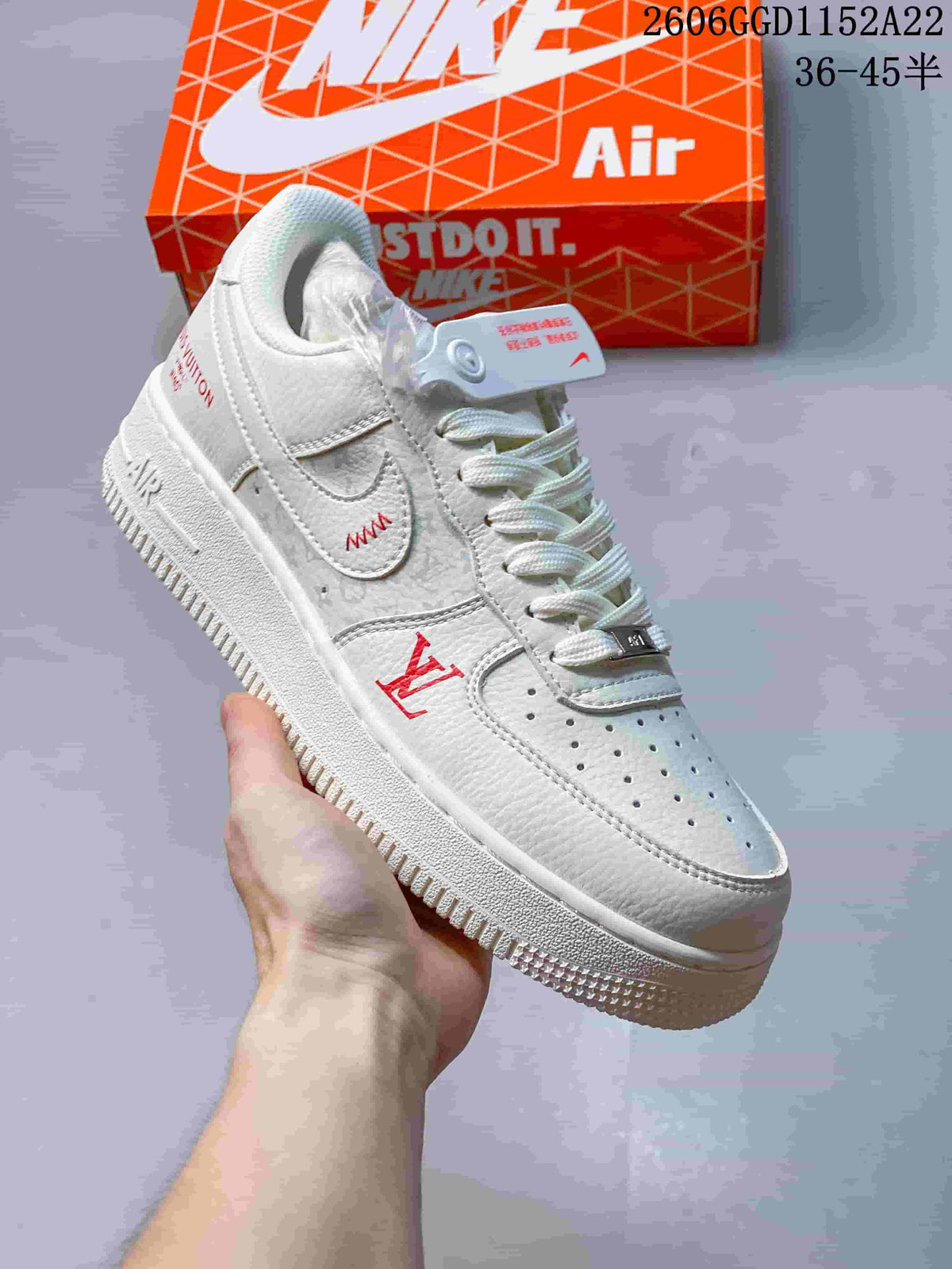Close-up of a white low-top sneaker with red decorative details and a perforated toe.