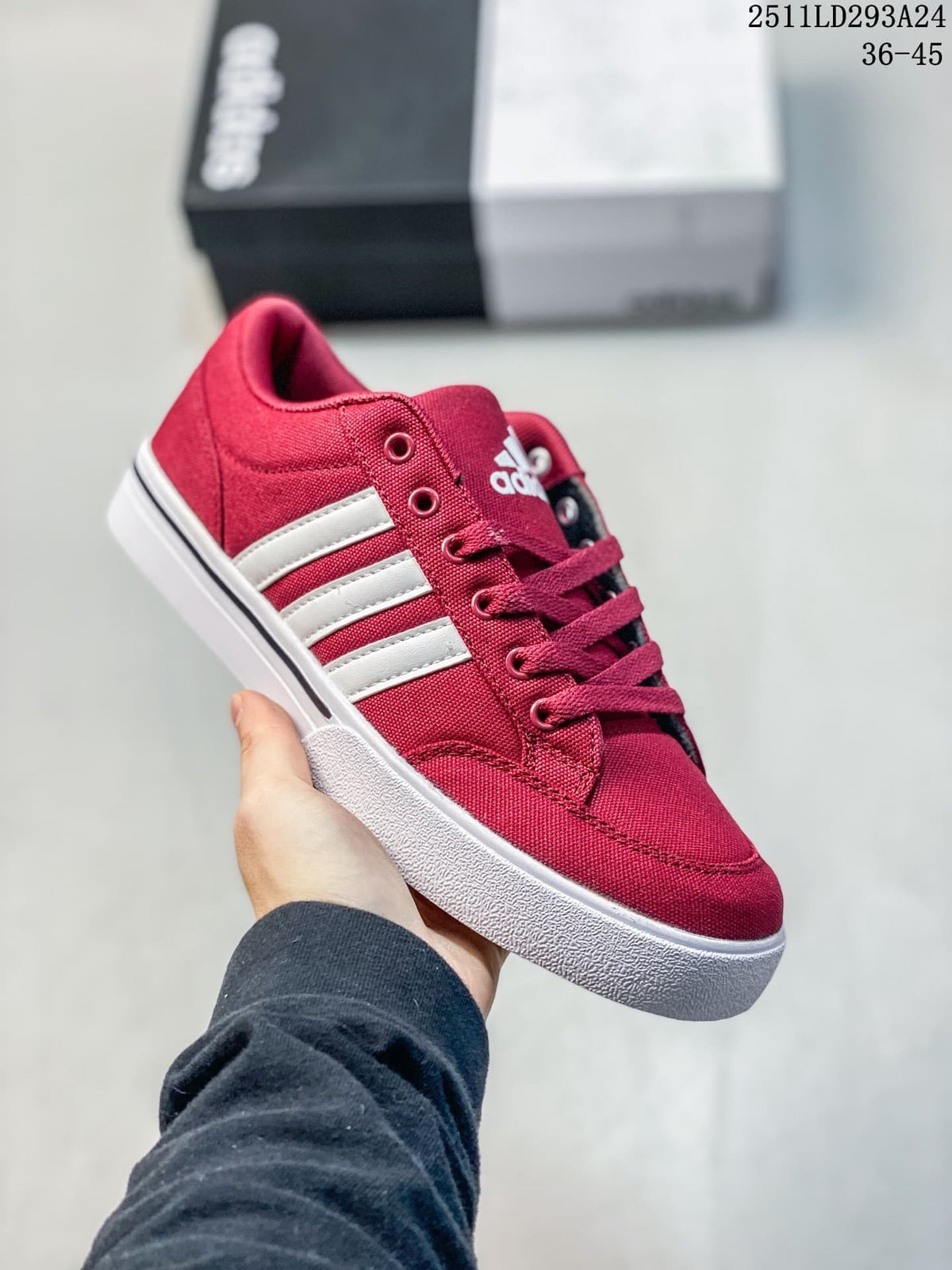 Angled side view of the burgundy sneaker with white stripes and a white sole