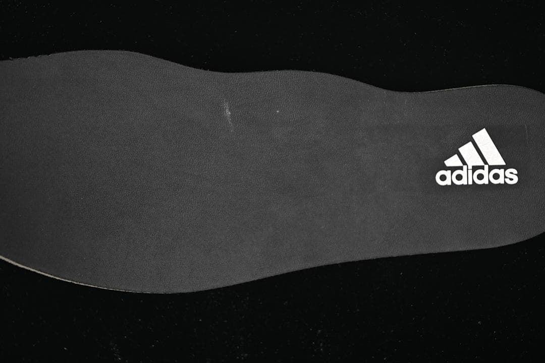 Dark shoe insole with adidas branding.