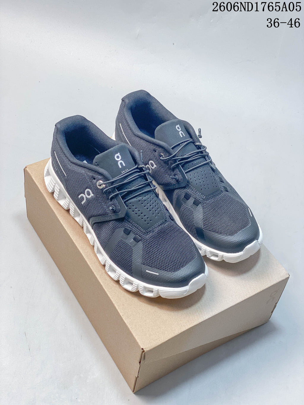 Pair of charcoal gray On Cloud 5 sneakers with white soles, shown on a box