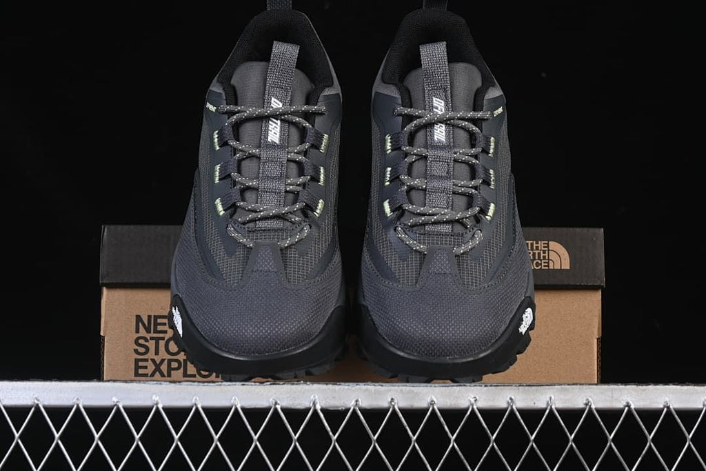 Front view of the pair of dark gray shoes displayed on the box