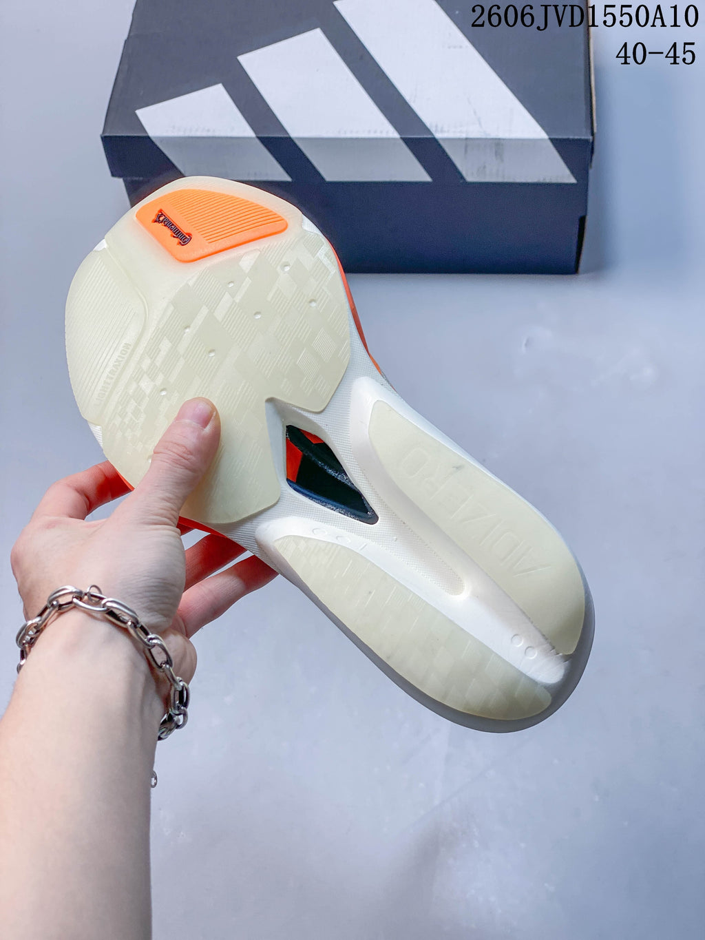 Underside of a cream Adidas running shoe showing the outsole and midfoot cutout.