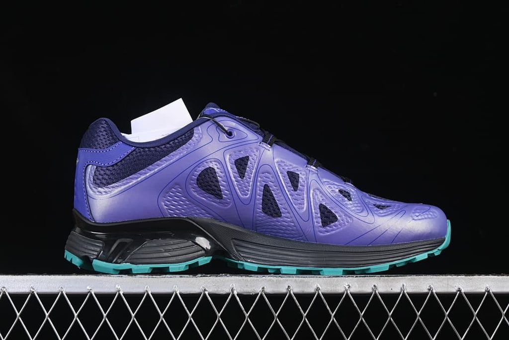 Side profile of the purple shoe with its black midsole and turquoise outsole.