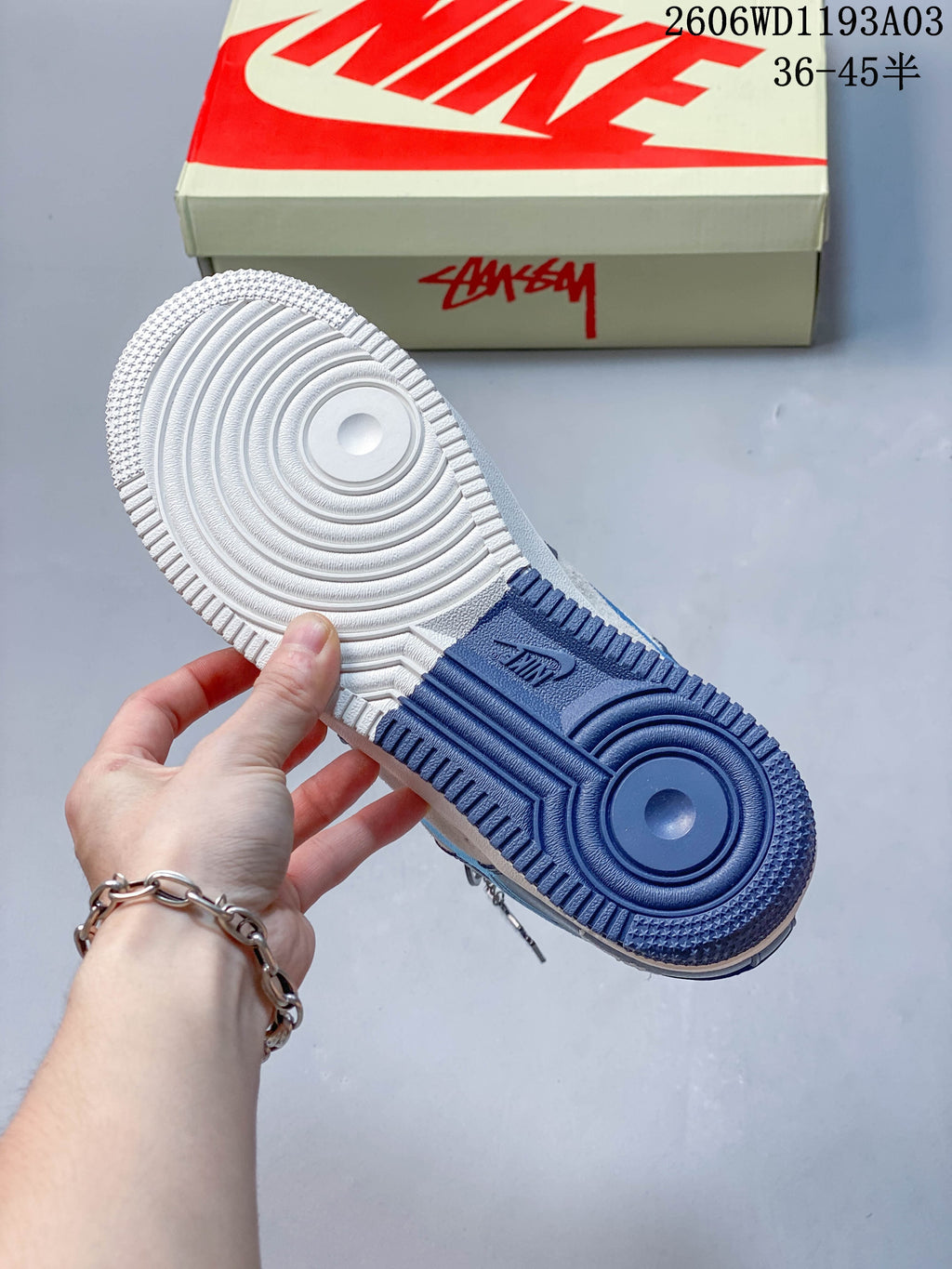 Underside of the sneaker showing a white and blue outsole