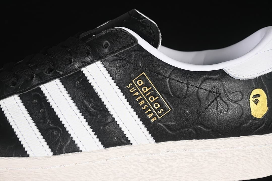 Close-up of the black embossed upper, white stripes, and gold-tone branding